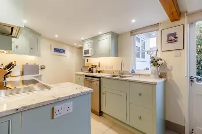 a kitchen with white cabinets and a window at 3 Bed in Woodbridge oc-h23 in Woodbridge