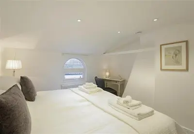 a white bedroom with a bed with towels on it at 2 Bed in Aldeburgh oc-tsc in Aldeburgh