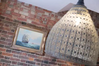 a mirror on a brick wall next to a picture at 2 Bed in Woodbridge oc-zep in Woodbridge