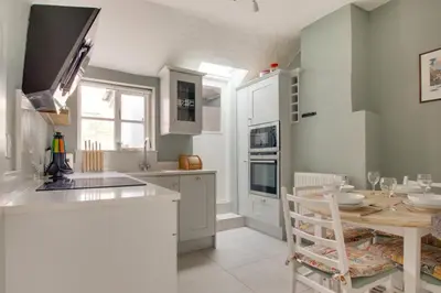 a kitchen with white cabinets and a table and a dining room at 2 Bed in Woodbridge oc-csn2 in Woodbridge