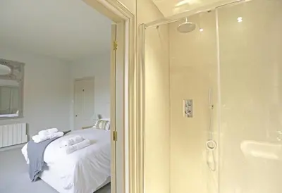 a bedroom with a shower and a bed with white sheets at 2 Bed in Orford oc-sfwco in Orford