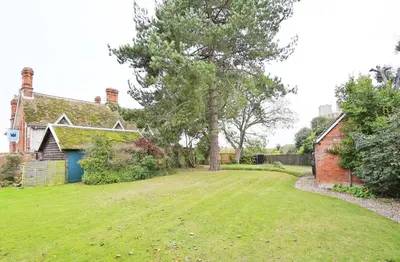 a yard with a house and a tree at 2 Bed in Orford oc-sfwco in Orford