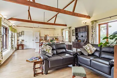 a living room with a couch and a kitchen at 1 Bed in St. James South Elmham Halesworth oc-t27361 in Saint James