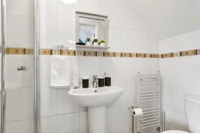 a white bathroom with a sink and a shower at Grab a Deal Today! Massive Home For Contractors & Parking for 4 in Chelmsford