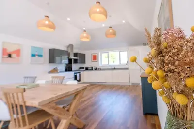 a kitchen and living room with a wooden table and a kitchen at Springfield, Westleton in Westleton