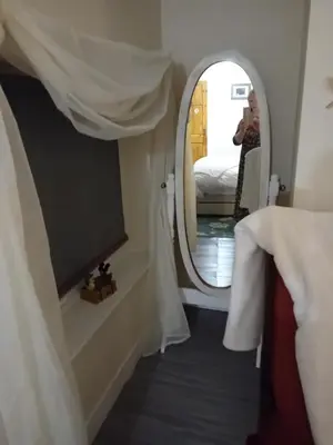 a view of a room with a mirror and a bed at Owls Roost in Stowmarket