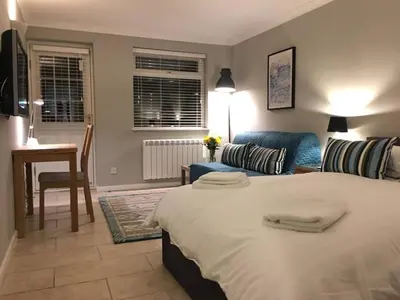 a bedroom with a large bed and a couch at Addenbrookes Flat 2 mins walk free Private Parking in Cambridge